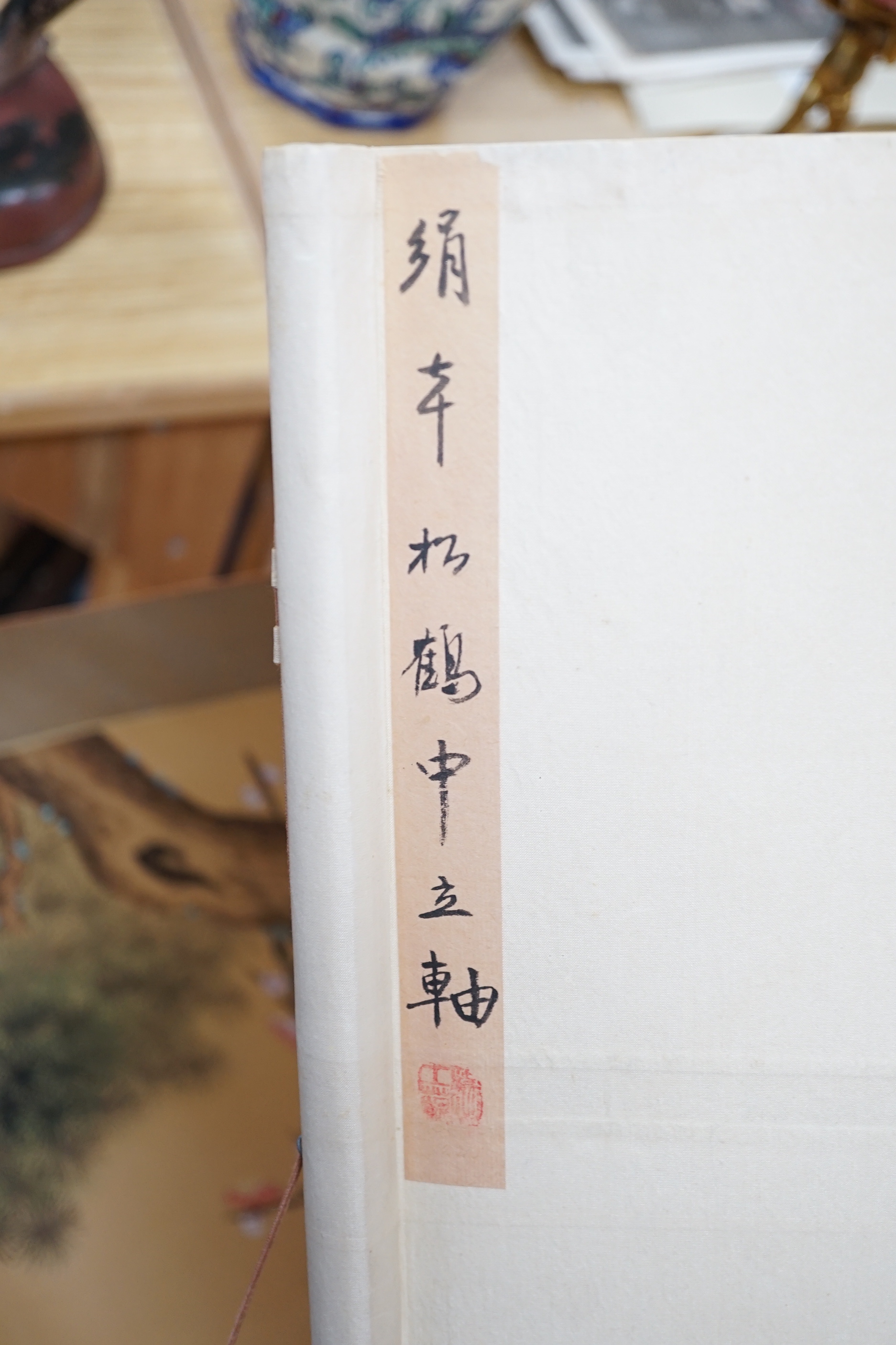 A 20th century Chinese hanging scroll watercolour on silk, two cranes on a pine tree, with brocade border, together with a blue Chinese silk table runner with brocade mon decoration
